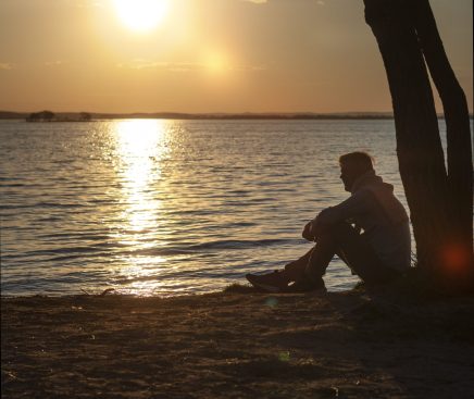 sad-contemplative-person-near-lake-min